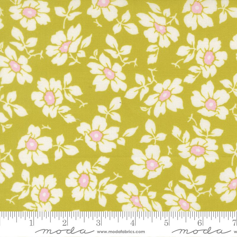 Floral fabric pattern featuring white flowers with pink centers and light green leaves on a yellow-green background, shown with a measuring ruler at the bottom indicating scale.