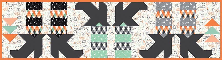 Quilted table runner of witches feet with Halloween colored socks with patterns in black, orange, gray, and green on a white background