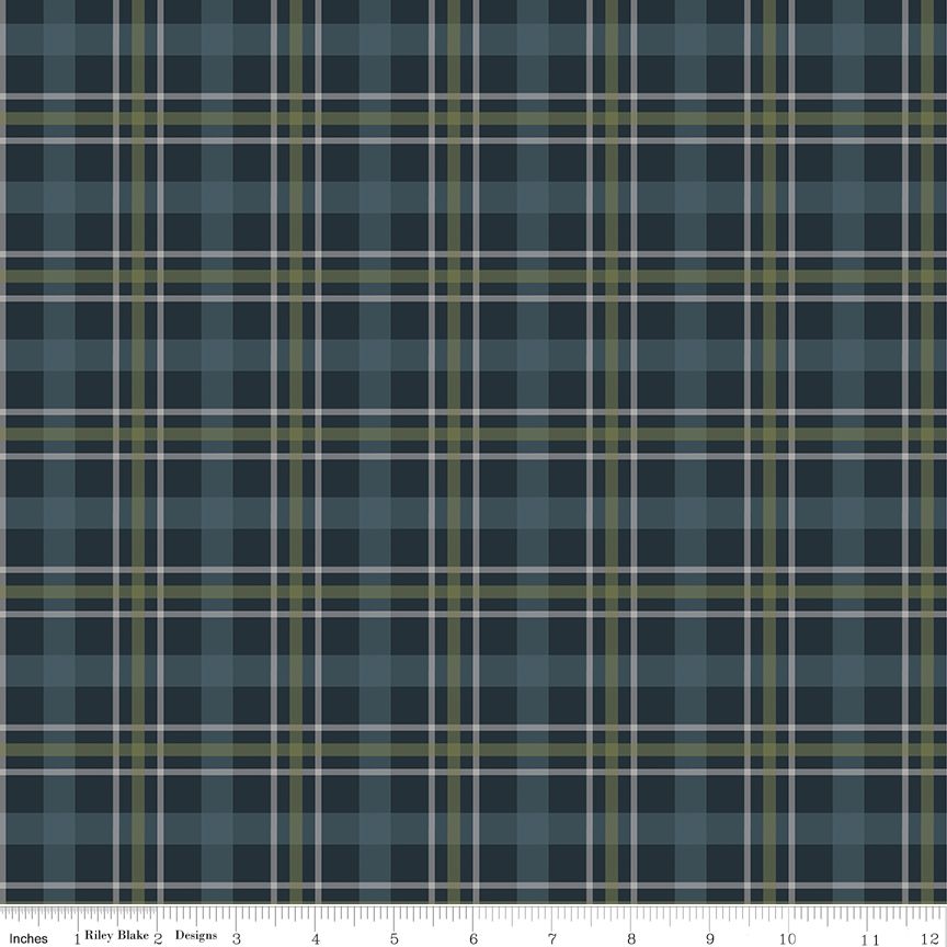 A close-up of a plaid fabric pattern in slate blue, navy, olive green, and white, with a ruler along the bottom edge showing measurement markings.