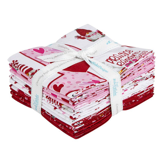 A bundle of 12 quilt fabrics from the  Gnomes In Love collection, tied with a white branded ribbon. The fabrics feature whimsical gnome characters, hearts, florals, and playful coordinates in a sweet Valentine-inspired palette of reds, pinks, and neutrals.