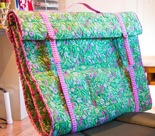 Floral-patterned bag with pink trim on a couch