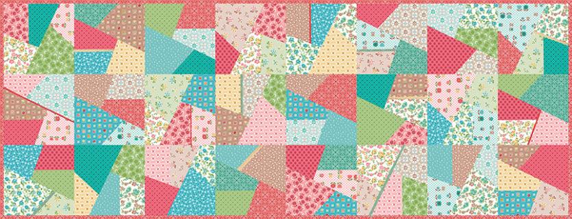 A colorful patchwork quilt design made of many geometric fabric pieces in pink, teal, green, yellow, and white with various prints and patterns.