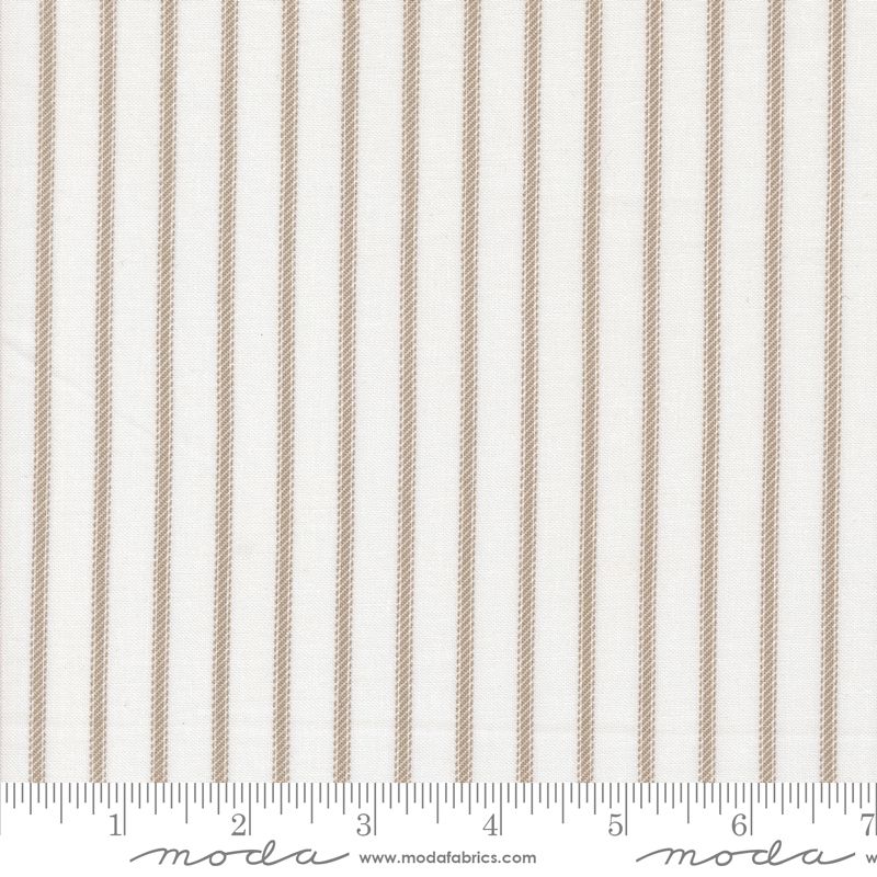 A close-up of a fabric pattern featuring vertical tan stripes on a white background, with a ruler at the bottom showing measurements and a Moda Fabrics watermark.