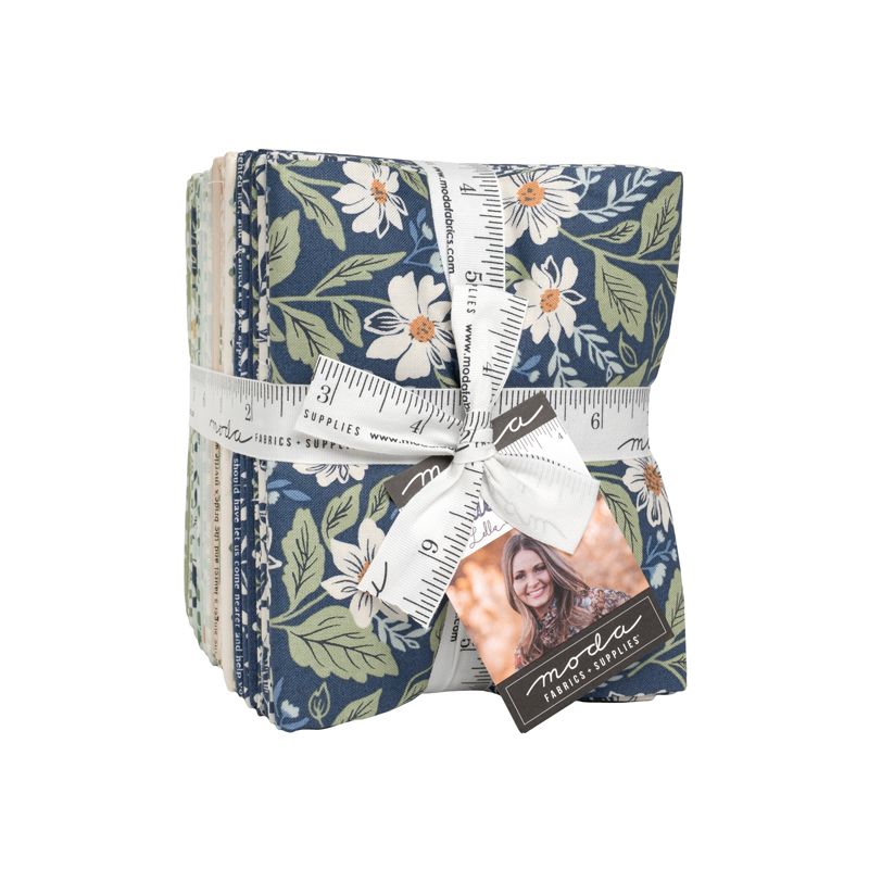 Pack of fabric squares with floral pattern and ruler, tied with ribbon, on a white background