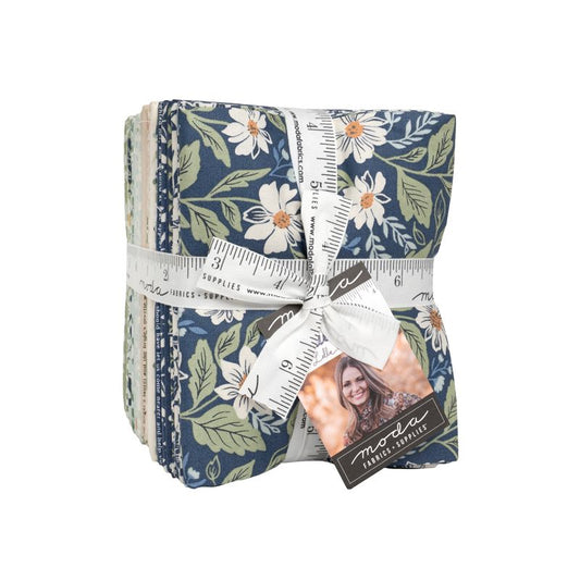 Pack of fabric squares with floral pattern and ruler, tied with ribbon, on a white background