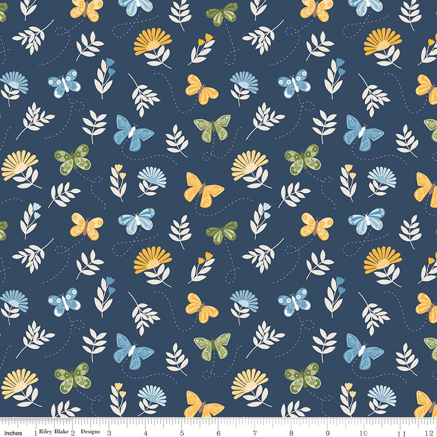 A repeating fabric pattern on a dark navy background featuring white leaves, yellow and blue butterflies, and small yellow flower clusters, with a ruler along the bottom edge showing scale.
