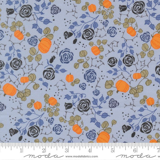 Fabric pattern with pumpkins and flowers on a blue background, featuring Moda label.