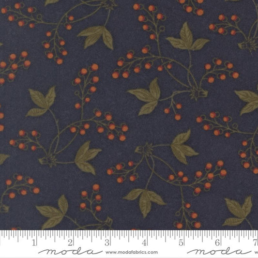 A close-up of a fabric pattern featuring olive green leaves and vines with small orange berries on a dark navy blue background, with a white ruler at the bottom showing measurements.