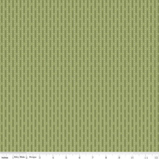 A close-up fabric pattern swatch showing a repeating vertical stripe design in muted olive green and sage, with a ruler scale along the bottom edge indicating inches and the brand Riley Blake Designs.