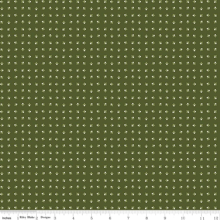 A repeating floral pattern fabric swatch in olive green and off-white, with a ruler along the bottom edge showing measurements.