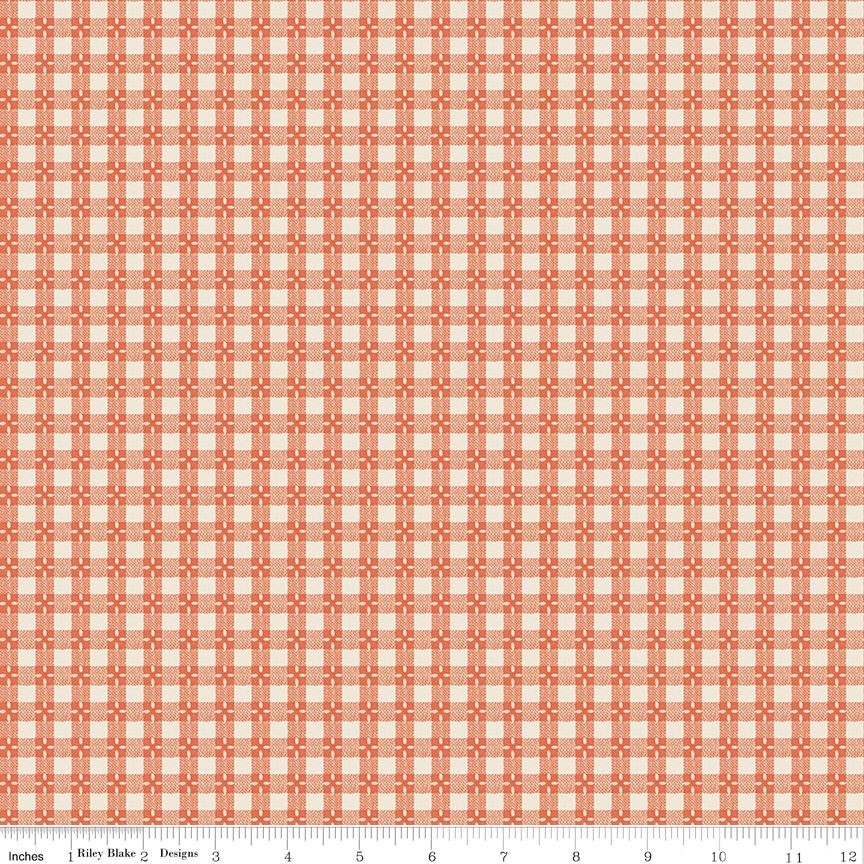 A close-up of a repeating fabric pattern in coral orange and cream, with a ruler along the bottom edge showing inches and the brand name Riley Blake Designs.