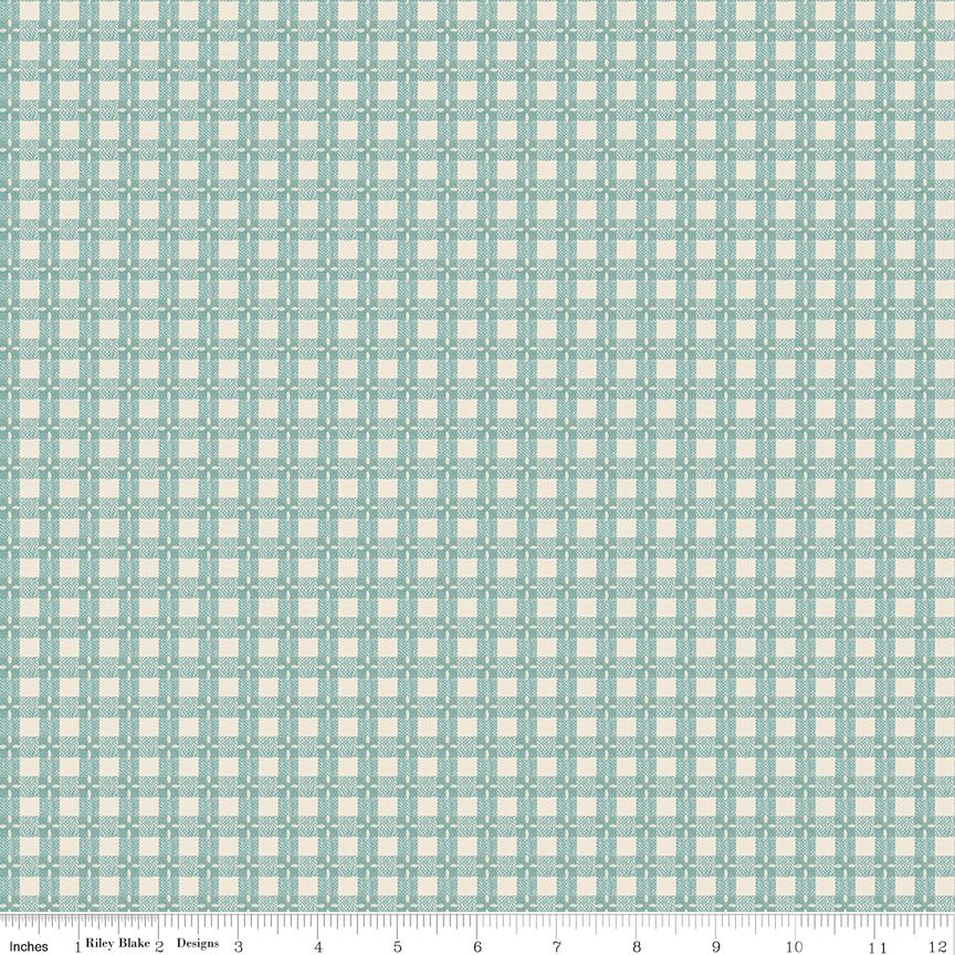 A repeating geometric pattern fabric swatch in light blue and cream, with a ruler scale along the bottom edge showing inches.