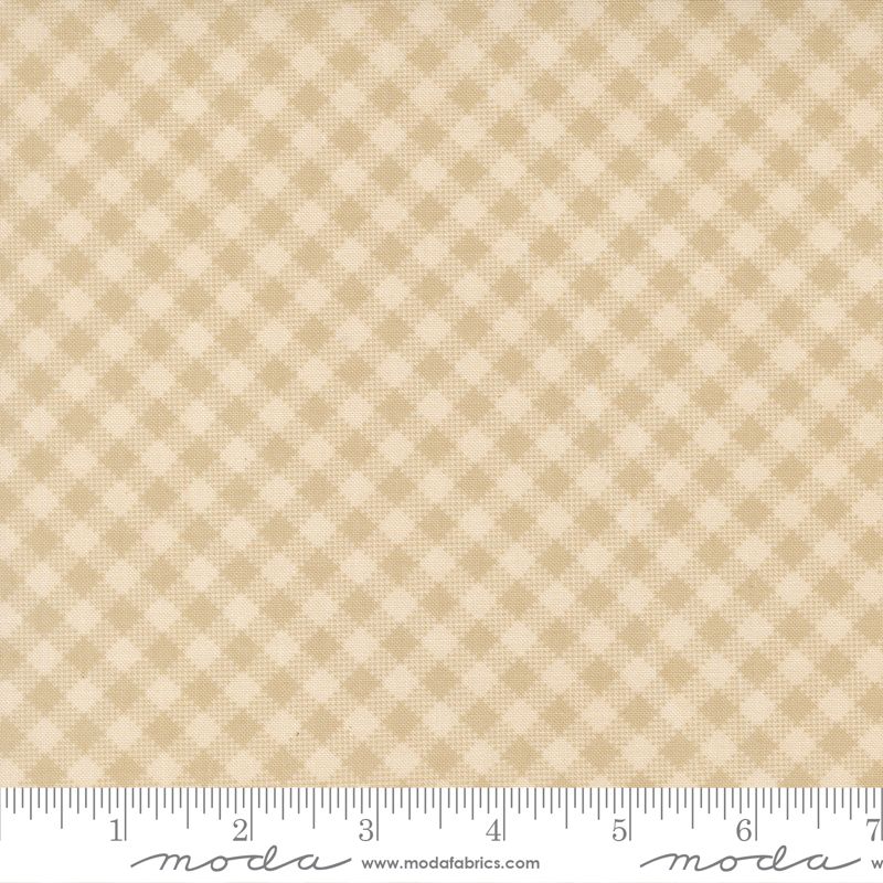 A close-up of a fabric pattern swatch showing a beige and cream gingham check design, with a measuring ruler along the bottom edge for scale. The brand name 'moda' is visible on the ruler.