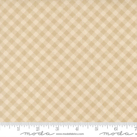 A close-up of a fabric pattern swatch showing a beige and cream gingham check design, with a measuring ruler along the bottom edge for scale. The brand name 'moda' is visible on the ruler.