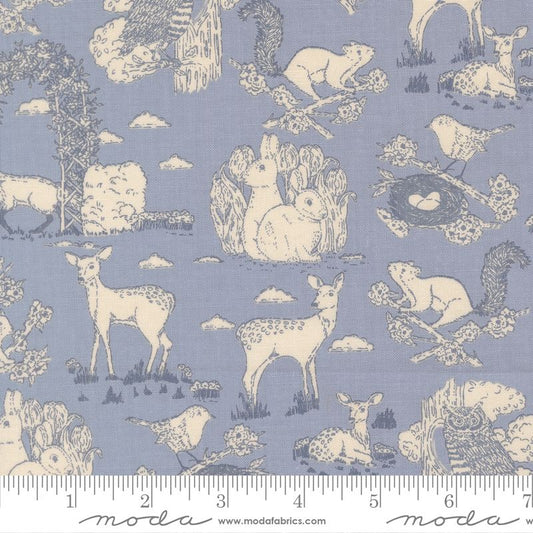 A fabric pattern featuring a sky blue background with a cream-colored toile print of woodland animals, including deer, rabbits, squirrels, birds, and trees. A white ruler is shown along the bottom edge to indicate scale.