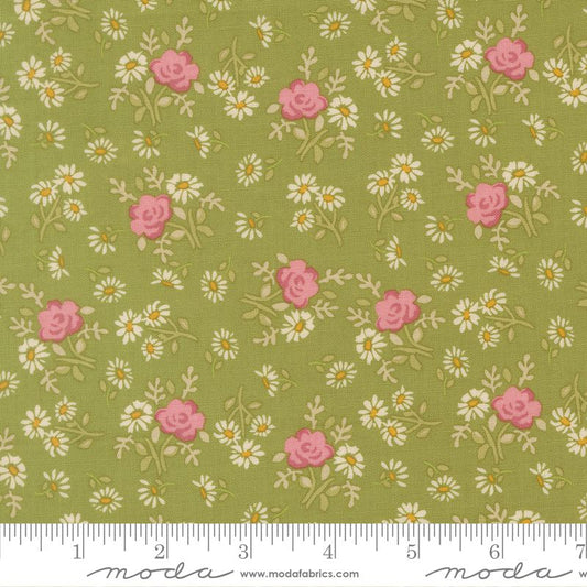 A close-up of a fabric pattern featuring pink roses and white daisies with yellow centers on an olive green background, with a measuring ruler along the bottom edge showing Modla branding.
