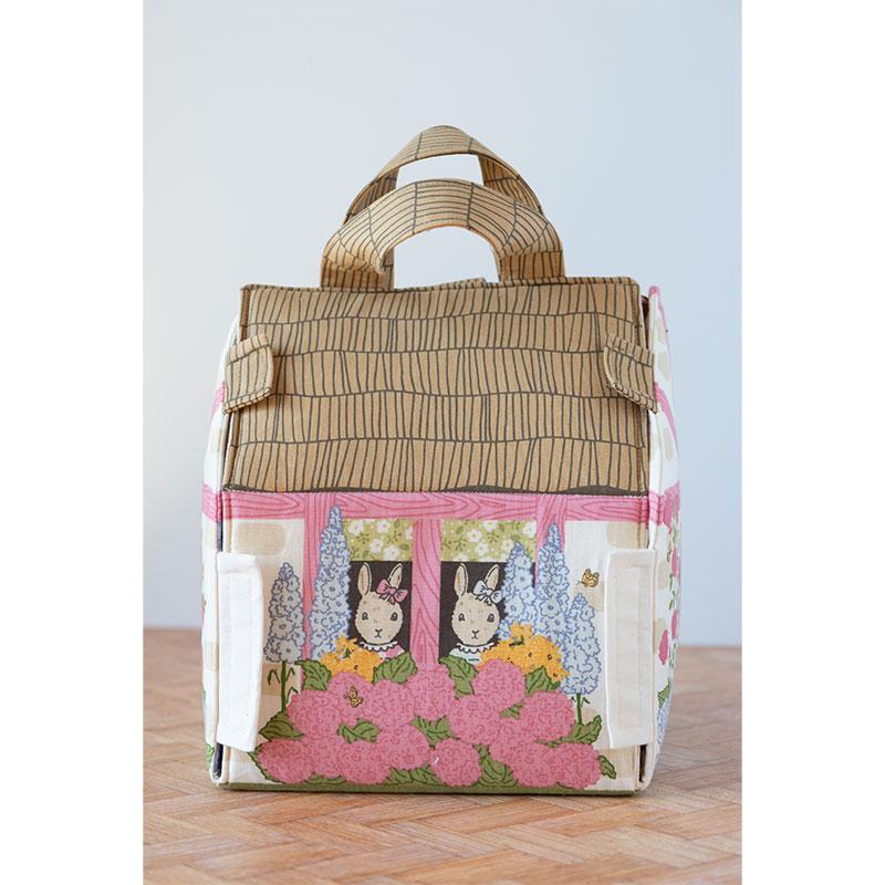 Decorative bag with cartoon characters and floral design on a wooden surface.