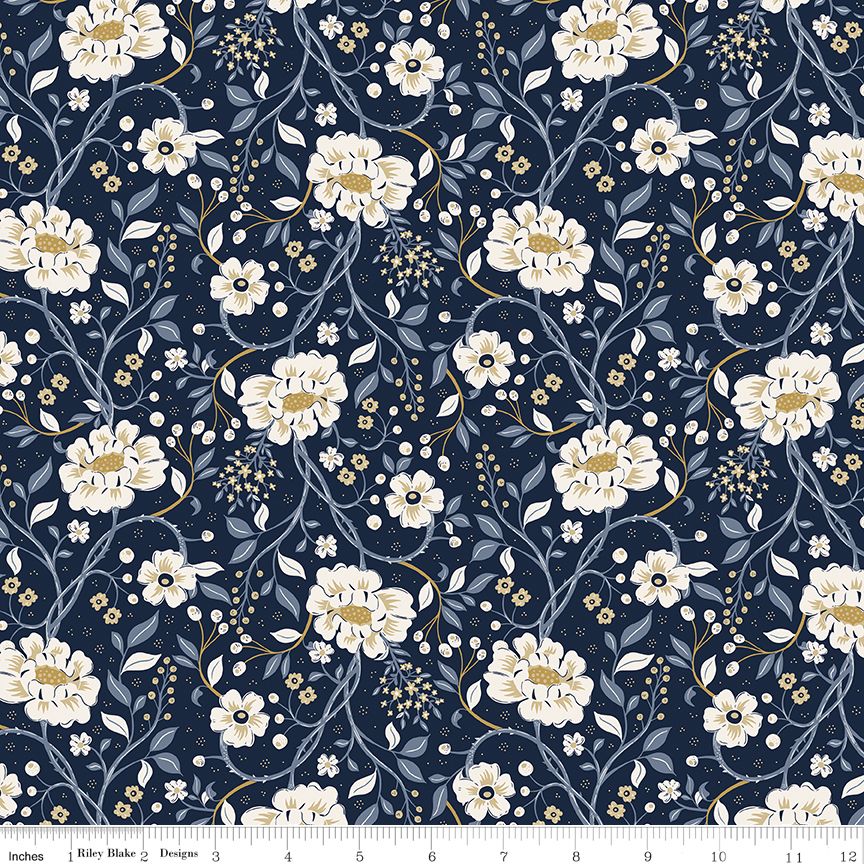 A repeating floral fabric pattern on a dark navy blue background, featuring large cream and white flowers with yellow centers, light blue-gray leaves, and delicate gold vine details. A ruler scale is visible along the bottom edge.