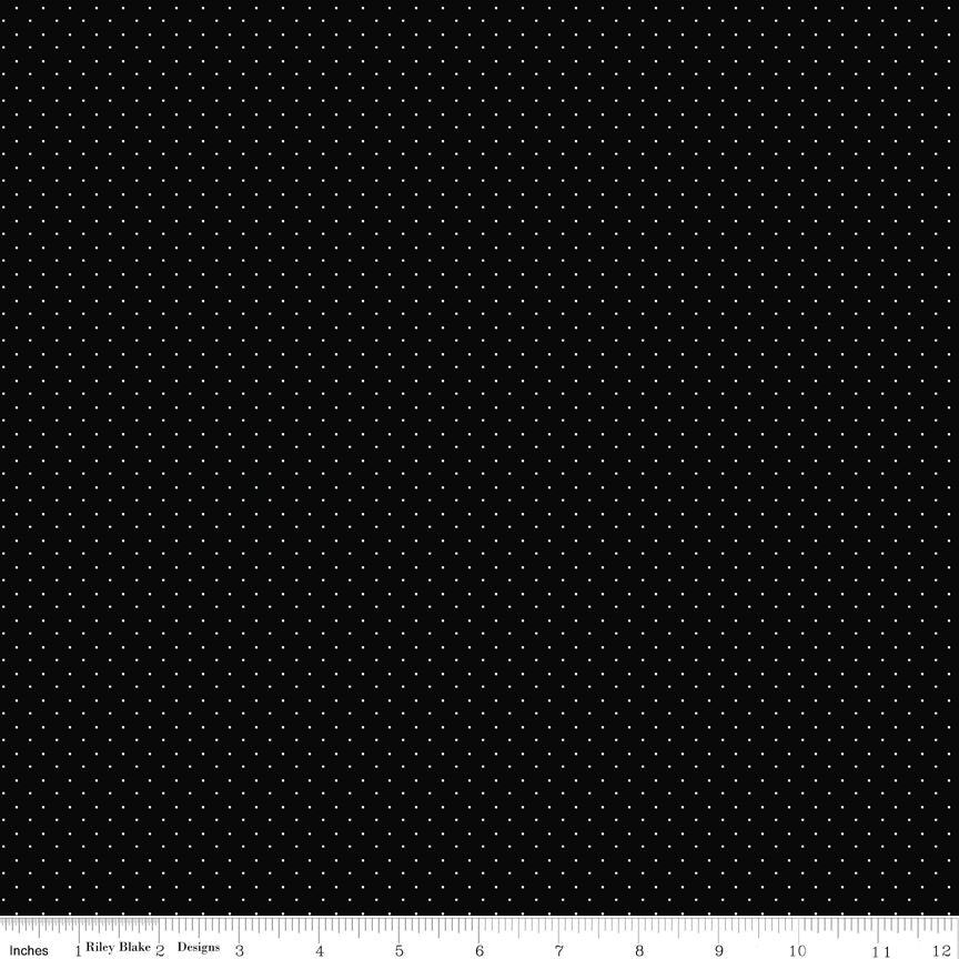 Black fabric with a repeating pattern of small white dots, shown flat with a ruler along the bottom edge for scale.