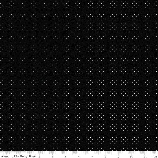 Black fabric with a repeating pattern of small white dots, shown flat with a ruler along the bottom edge for scale.
