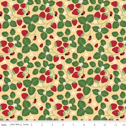 A repeating fabric pattern featuring red strawberries, green leaves, small white flowers, and ladybugs on a pale yellow background, with a ruler along the bottom edge showing scale.