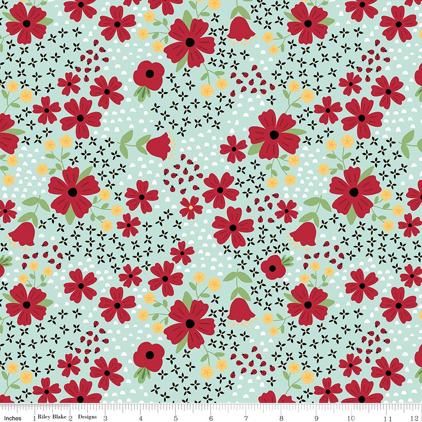 A repeating floral fabric pattern with red flowers, green leaves, black flowers, and small yellow flowers and ladybugs on a pale blue background. A ruler strip appears along the bottom edge.