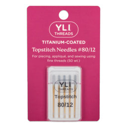 YLI Threads titanium-coated topstitch needles packaging on a pink background
