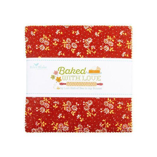 A charm square pack with a red background and white floral pattern, wrapped in a white paper band that reads 'Baked with Love' and shows the brand 'Riley Blake'.