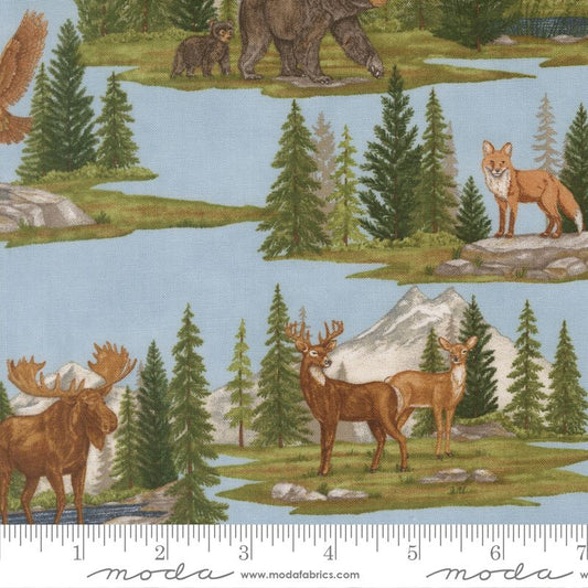 Nature-themed fabric with animals like deer, moose, and bear on a pale blue background featuring a ruler at the bottom for scale.