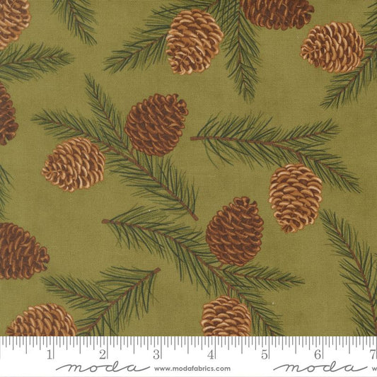Fabric pattern with pinecones and branches on a green background, featuring Moda label.