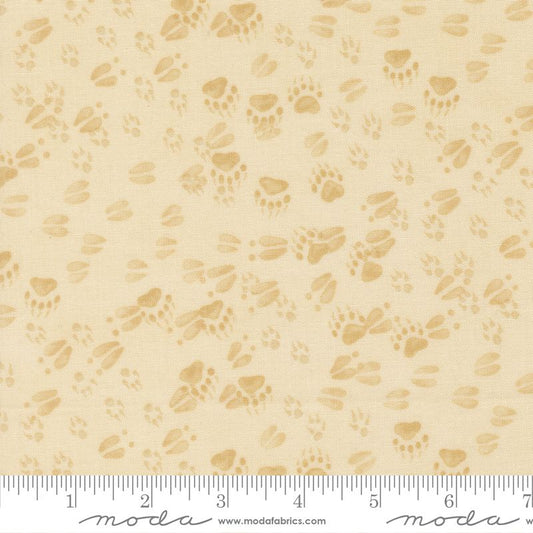 Cream fabric with brown paw print pattern and Moda label