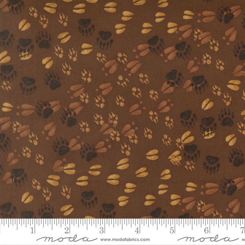 Brown fabric with paw print pattern and Moda label