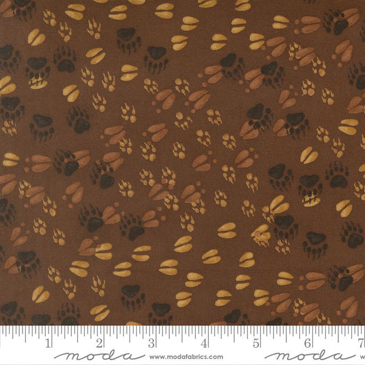 Brown fabric with paw print pattern and Moda label