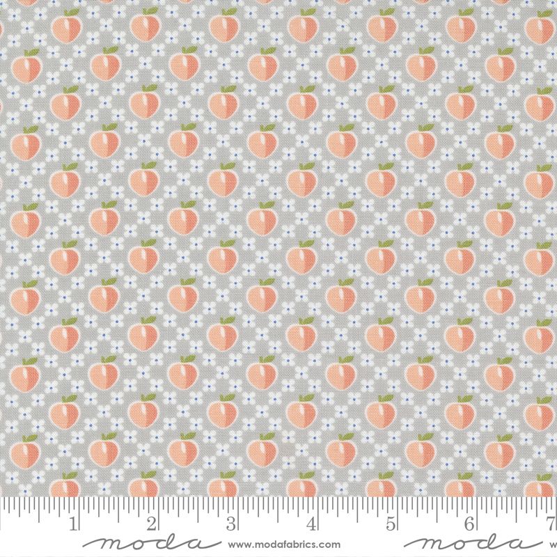 A repeating fabric pattern featuring peach illustrations on a light gray background with small white and blue floral dots. A ruler along the bottom edge shows measurement markings and includes the Modas Fabrics watermark.