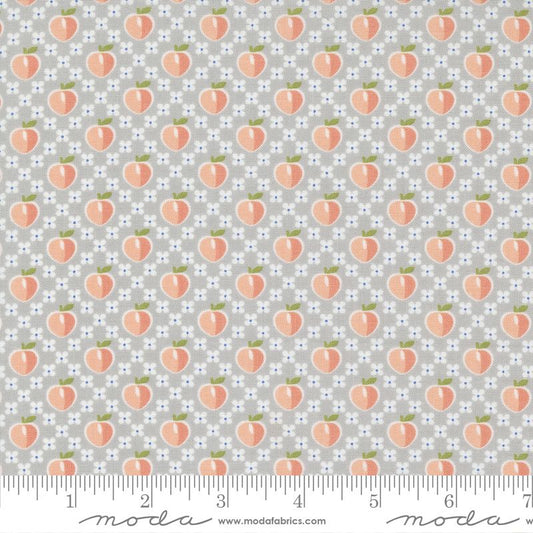 A repeating fabric pattern featuring peach illustrations on a light gray background with small white and blue floral dots. A ruler along the bottom edge shows measurement markings and includes the Modas Fabrics watermark.