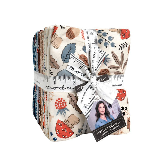 Pack of fat quarters with floral and leaf patterns, tied with a ruler, on a white background.