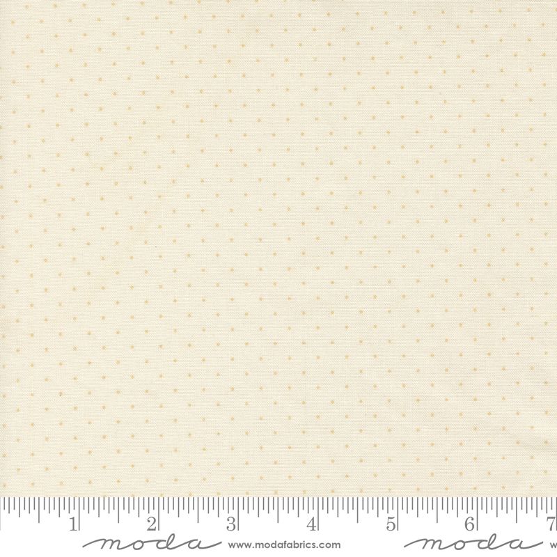 Cream-colored fabric with a small, evenly spaced tan polka dot pattern, shown with a measuring ruler at the bottom to indicate scale. The brand name 'Moda' is visible on the ruler.