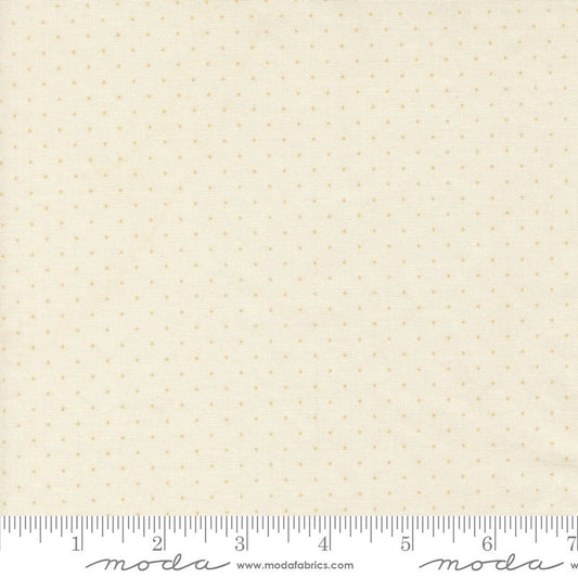 Cream-colored fabric with a small, evenly spaced tan polka dot pattern, shown with a measuring ruler at the bottom to indicate scale. The brand name 'Moda' is visible on the ruler.
