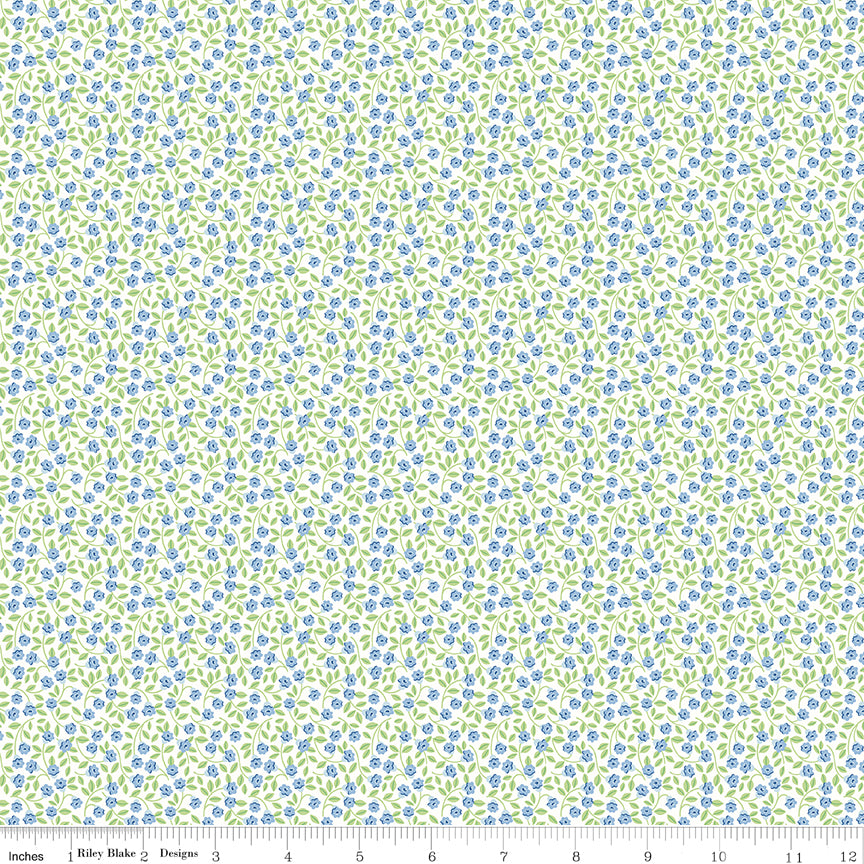 White fabric with tiny blue flowers and green leaves. 