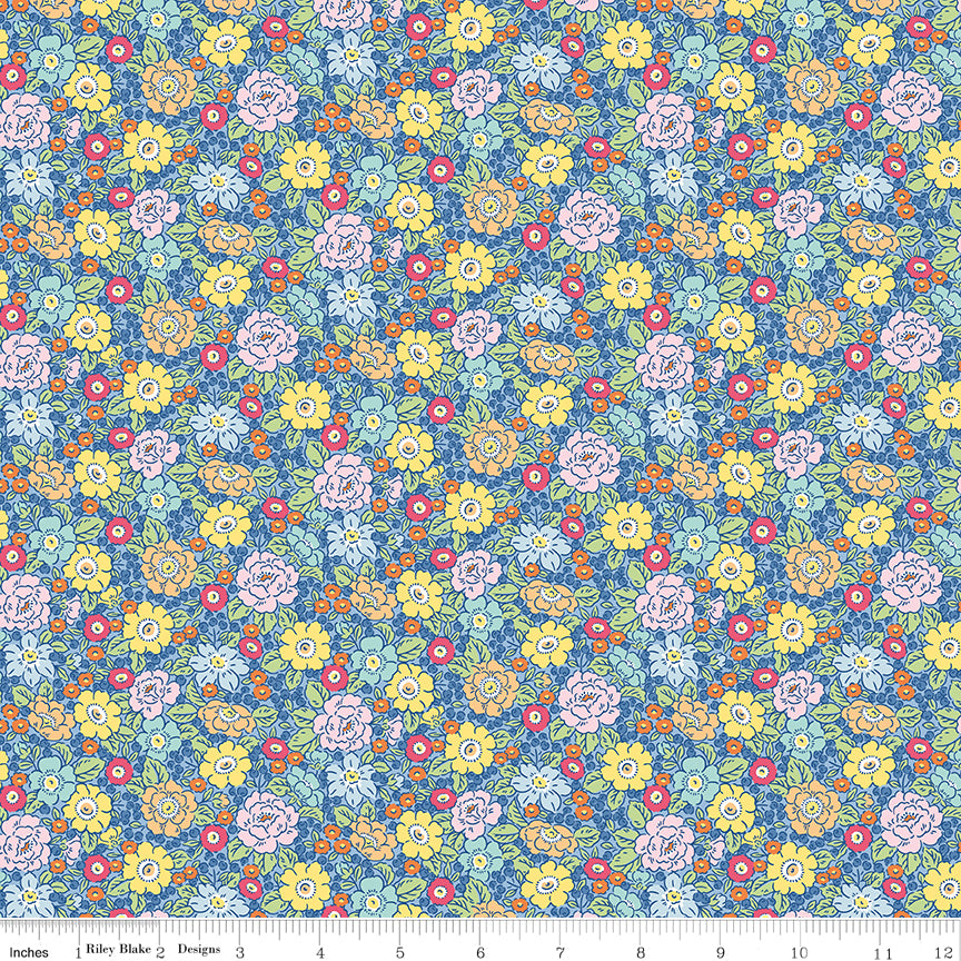 Blue, yellow, pink and orange flowers on this bright fabric with a ruler at the bottom. 