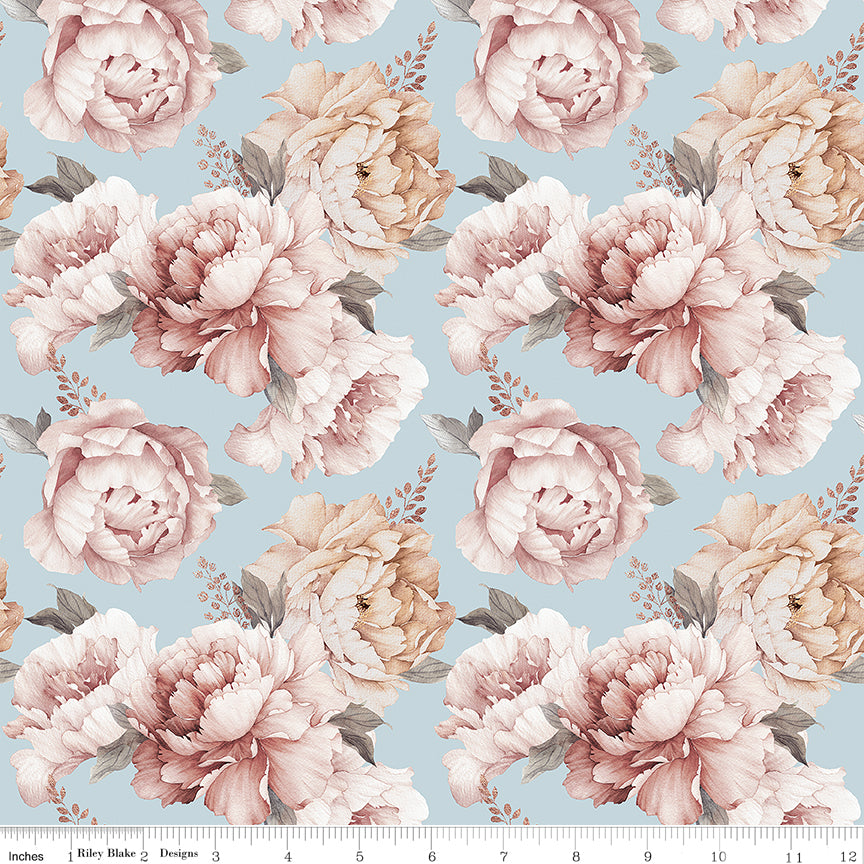 A repeating floral pattern featuring large blush pink and cream peony-like flowers with muted green leaves on a pale blue background, shown as a fabric or wallpaper print with a small ruler edge visible along the bottom.