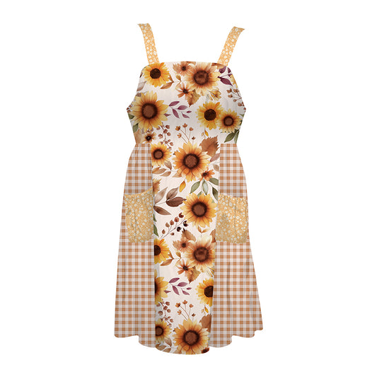 A sleeveles sapron with a patchwork design featuring sunflower prints, brown gingham checks, and textured floral panels on a white background.